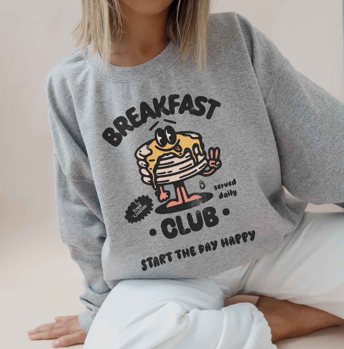 Grey crewneck jumper with retro breakfast club graphic printed on the front